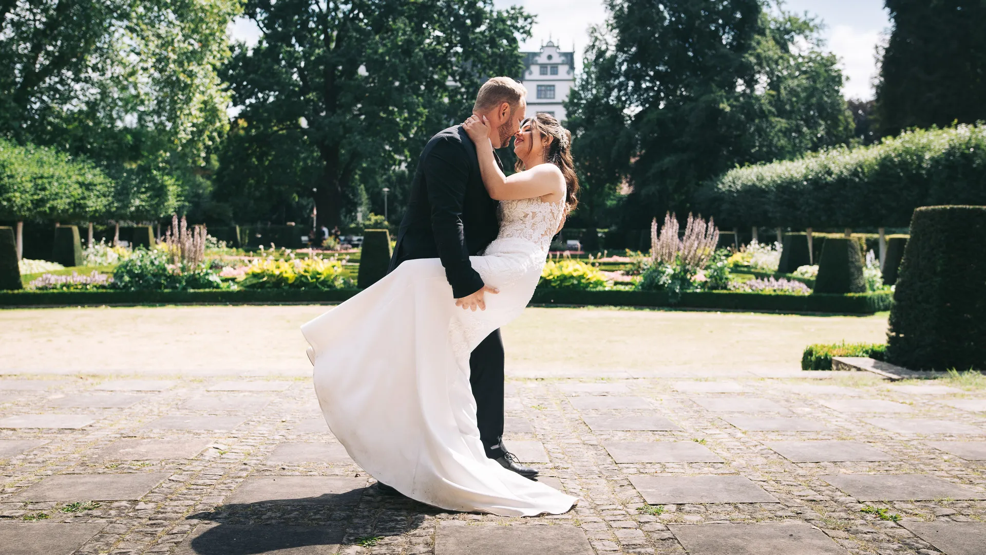 hochzeitsfotograf-wolfsburg-brautpaar-pose-im-barockgarten Ein frisch verheiratetes Brautpaar posiert im Barockgarten am Schloss Wolfsburg