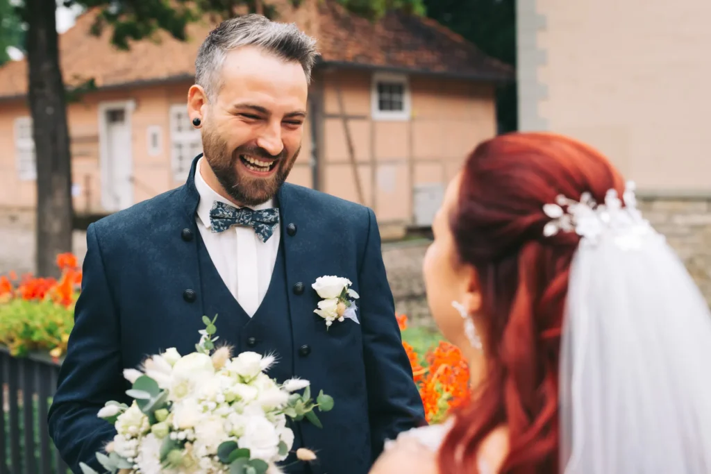 Der Bräutigam strahlt als er die Braut beim First Look am Tag ihrer Hochzeit in Fallersleben zum ersten Mal sieht
