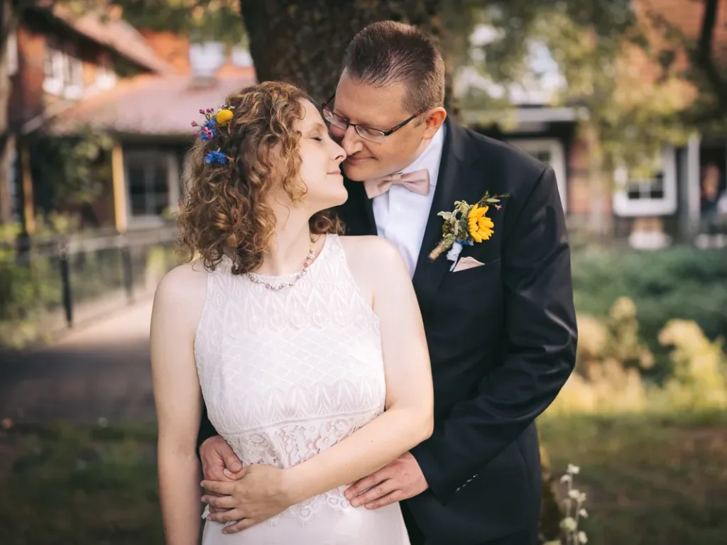 Verliebtes Brautpaar unter einem Baum während eines Fotoshootings vor der Brackstedter Mühle