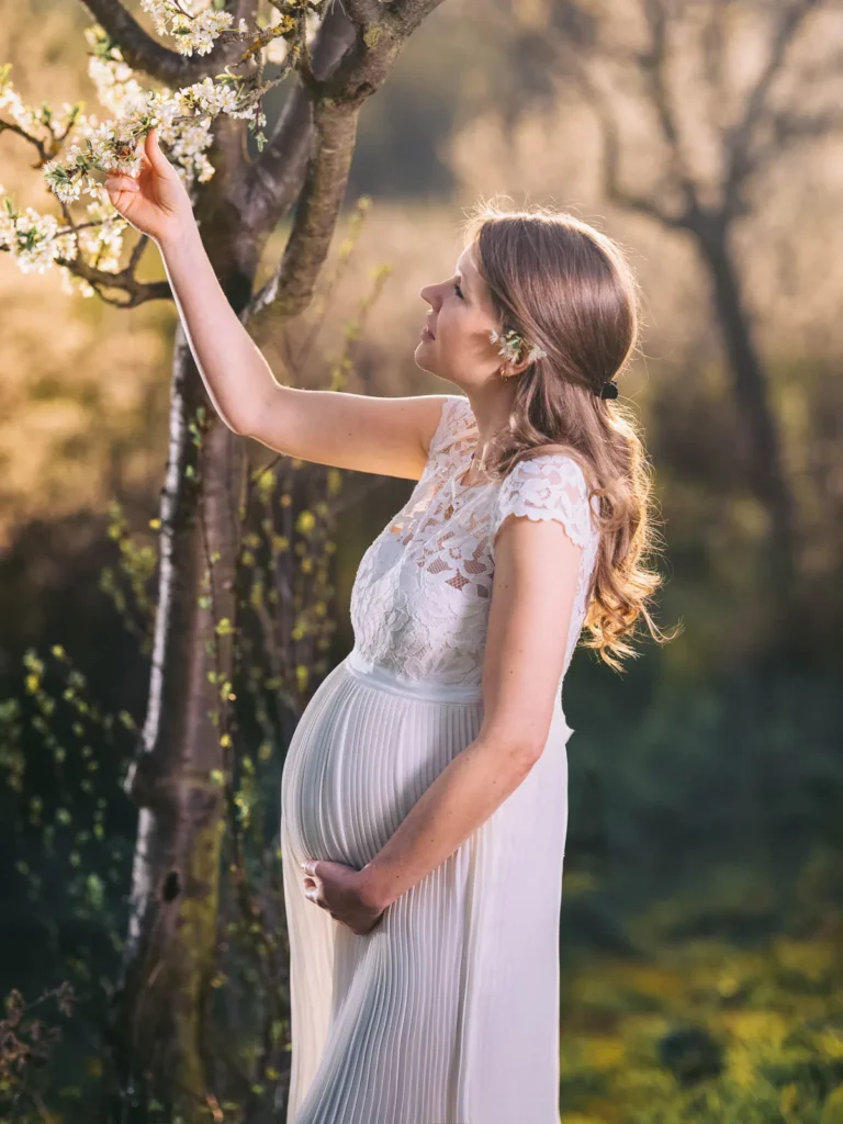 Foto einer Braut in weißem Brautkleid mit Babybauch am Tag ihrer Hochzeit in Wolfsburg.