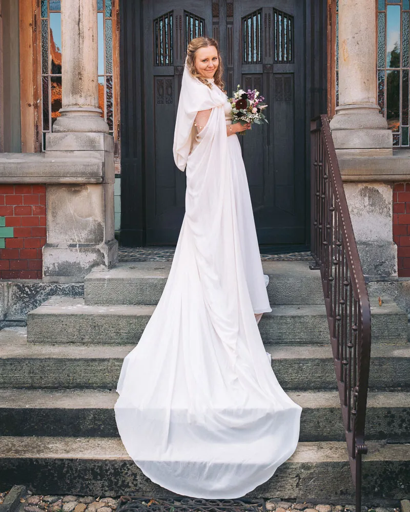Braut mit langem Brautkleid bei einem Fotoshooting im FarmInn Wittingen