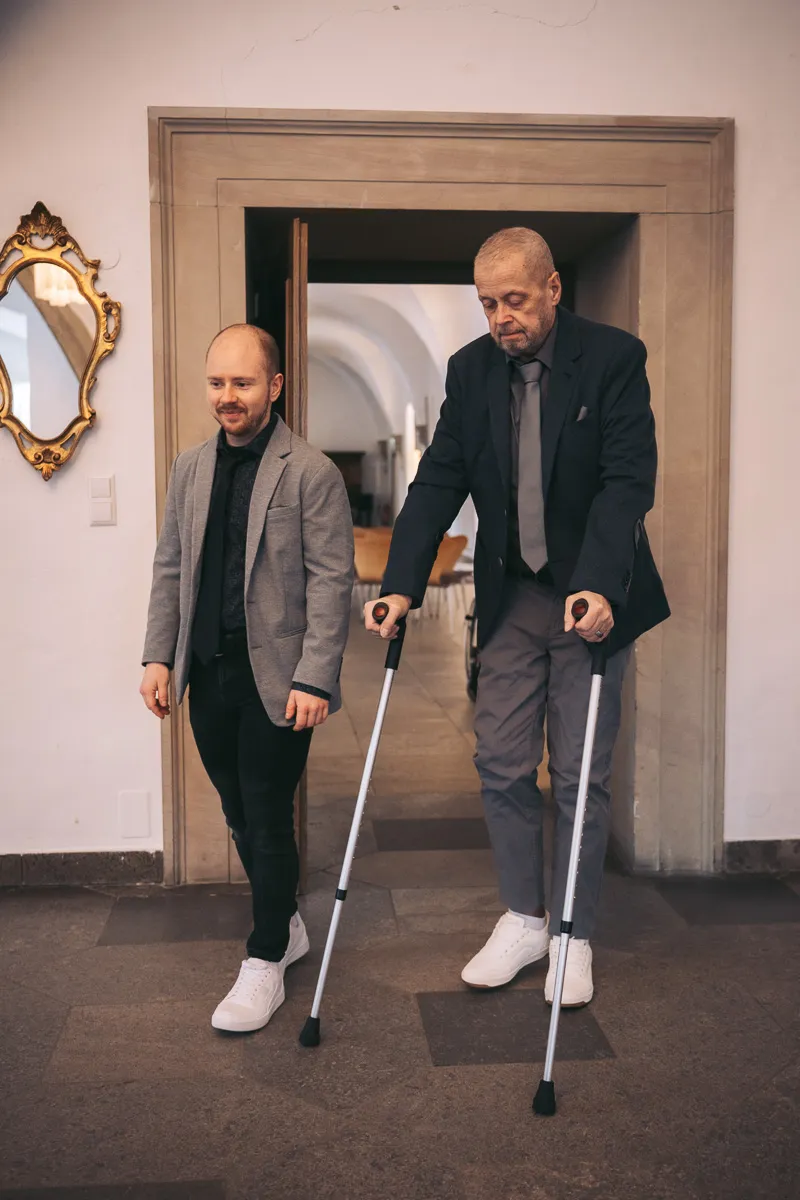 Zwei Bräutigame kurz vor ihrer Trauung im Wolfsburger Schloss. Der ältere der beiden geht auf Gehhilfen in das Trauzimmer.