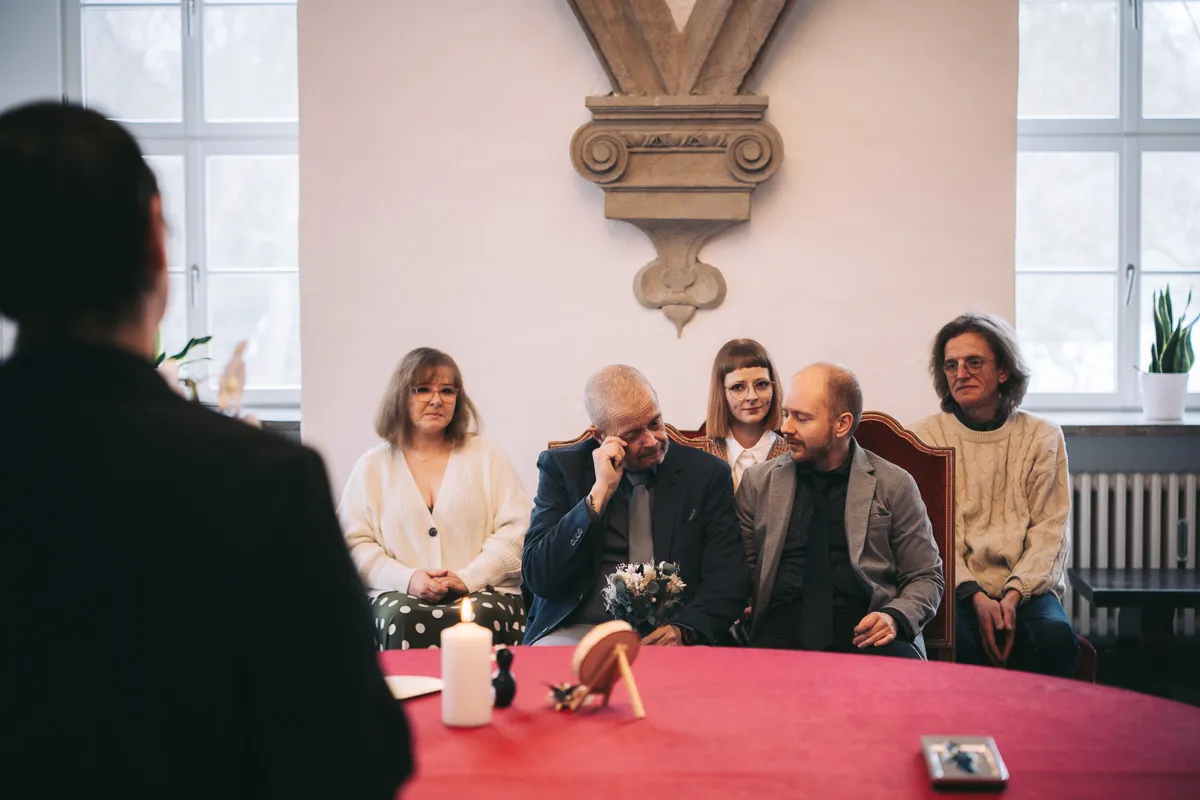 Zwei Bräutigame mit Gästen während der Trauung im Schloss Wolfsburg